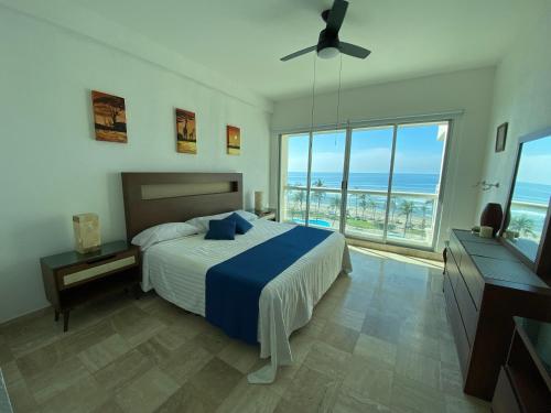 a bedroom with a bed and a view of the ocean at Mayan Playa Departamento Uxmal in Acapulco