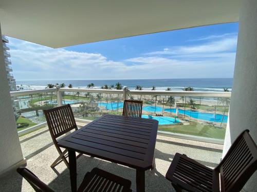 a balcony with a table and chairs and the ocean at Mayan Playa Departamento Uxmal in Acapulco