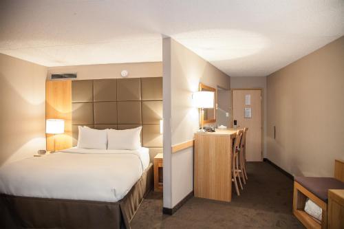 a hotel room with a bed and a desk at iHOTEL & Conference Centre Red Deer in Red Deer