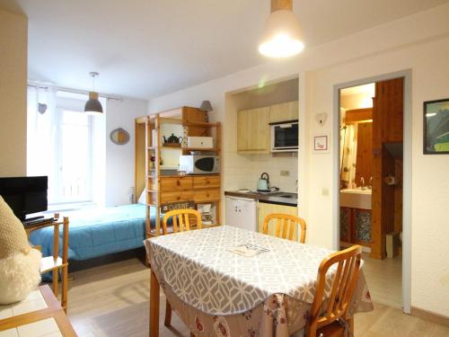 une cuisine et un salon avec une table et des chaises dans l'établissement Appartement F1 bis en hyper-centre du Mont-Dore avec ascenseur - FR-1-415-144, à Le Mont-Dore