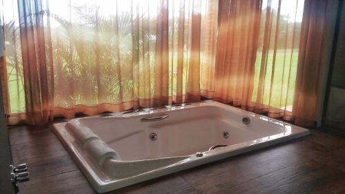 a bath tub sitting in front of a window at Tenondé Park Hotel in São Miguel das Missões