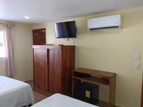a room with two beds and a tv on the wall at hotel rio mar in Puerto Vallarta