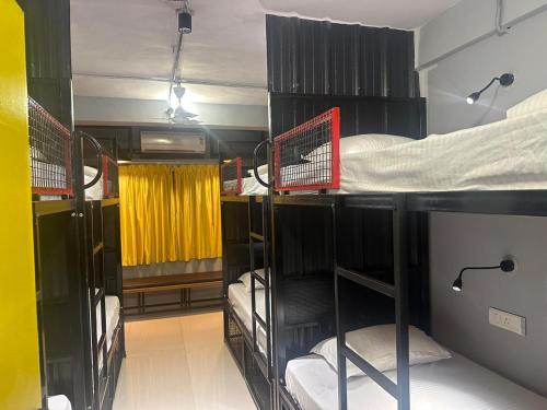 a room with three bunk beds in a room at Travotale Hostel and CoWork Koregaonpark Pune in Pune