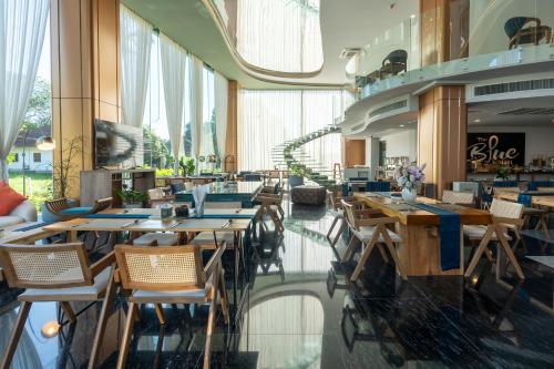 a restaurant with wooden tables and chairs in a building at The Blue Mavi Hotel in Chalong 