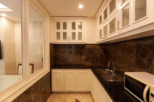 a kitchen with white cabinets and a sink at Samdi Grand Danang in Da Nang