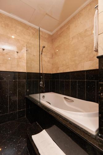 a bathroom with a tub and a glass shower at Samdi Grand Danang in Da Nang