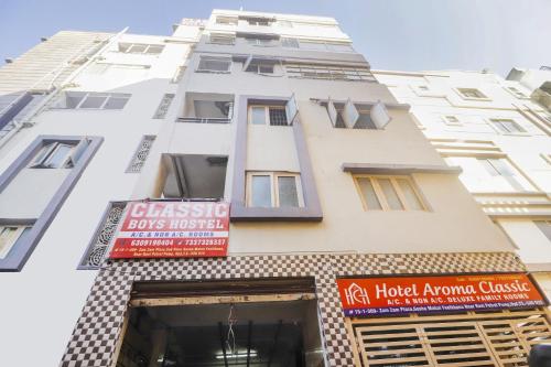 a tall white building with signs on it at Hotel O Aroma Classic Near Nampally Railway station in Hyderabad