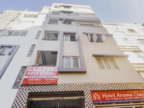 a tall white building with a sign on it at Hotel O Aroma Classic Near Nampally Railway station in Hyderabad