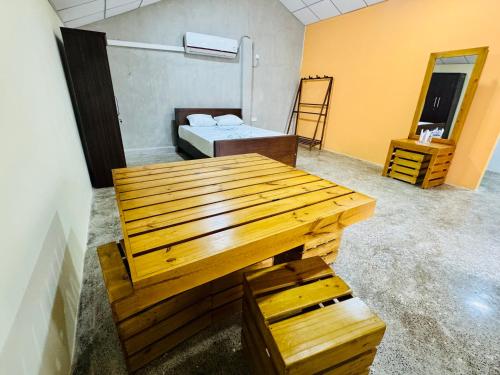 a room with a wooden table and a bed at Induwara Arana in Kurunegala