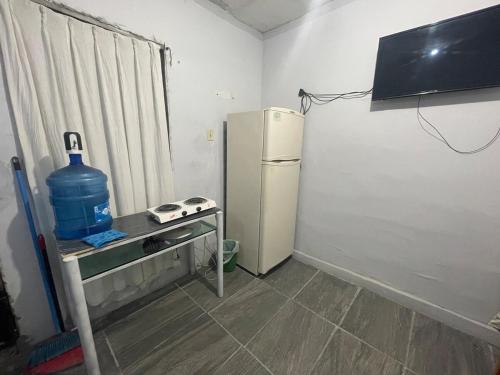 a kitchen with a refrigerator and a table with a water bottle at Separate apartment in guesthouse in Manuel F. Martínez