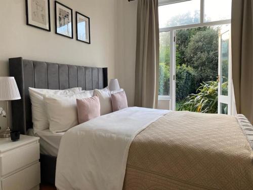 a bedroom with a large bed with a window at Beautiful one bed garden flat in Muswell hill in London