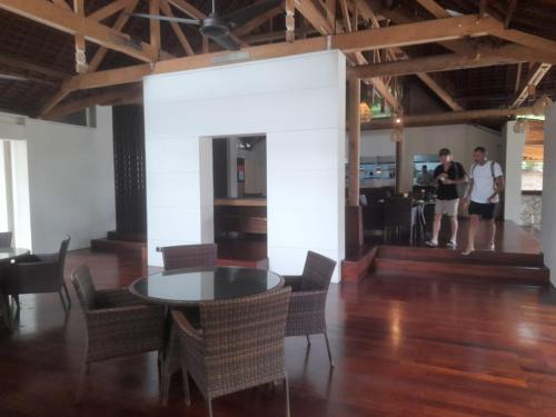 two people standing in a room with a table and chairs at The Royal Beach Seminyak Bali in Seminyak