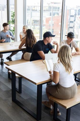 a group of people sitting at tables in a classroom at Summer House Melbourne in Melbourne