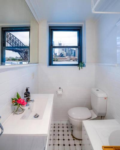a white bathroom with a toilet and a window at Best Harbour Views & location in Sydney in Sydney