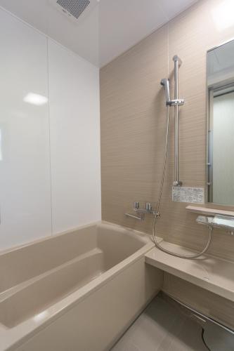 a bathroom with a bath tub and a sink at Comfort House In Miyakojima in Miyako-jima