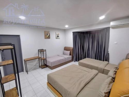 a bedroom with two beds and a couch in it at Royale Villa Private Pool Batu Gajah Ipoh Perak in Batu Gajah