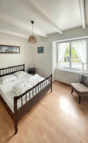 une chambre avec un lit, une chaise et une fenêtre dans l'établissement Maison accueillante à Fouesnant avec grand jardin, à Fouesnant