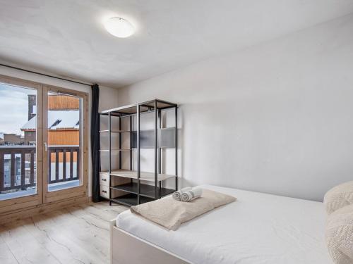 une chambre avec un lit et une grande fenêtre dans l'établissement Val Thorens - Spacieux Appartement 6 Pers. - FR-1-640-74, à Val Thorens