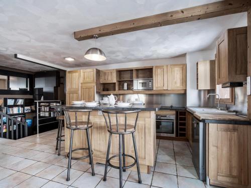 une cuisine avec des placards en bois et des tabourets de bar dans l'établissement Val Thorens - Spacieux Appartement 6 Pers. - FR-1-640-74, à Val Thorens