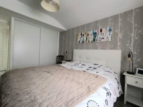une chambre avec un grand lit blanc dans une pièce dans l'établissement Maison bord de mer pour 4 pers., animaux acceptés, WiFi, parking - FR-1-364-175, à Saint-Brévin-les-Pins