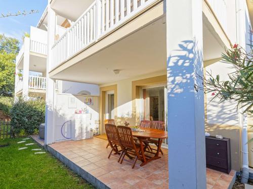 a patio with a wooden table and chairs at Grand appartement lumineux avec jacuzzi et grande terrasse à Bayonne - FR-1-3-623 in Bayonne