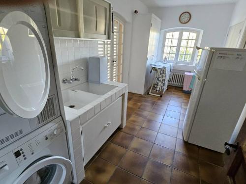 une salle de bain avec un lavabo et une machine à laver dans l'établissement Villa de Maître pour 12 avec piscine privée aux Issambres - FR-1-768-111, à Sainte-Maxime
