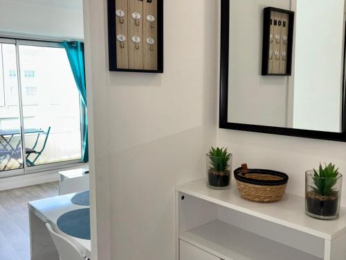 un salon avec une armoire blanche et des plantes dans l'établissement Appartement cosy proche mer à Saint Hilaire de Riez - FR-1-323-561, à Saint-Hilaire-de-Riez