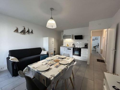 Il comprend un salon avec une table à manger et une cuisine. dans l'établissement Appartement moderne 2 pièces avec parking à Saint-Hilaire-de-Riez - FR-1-224C-331, à Saint-Hilaire-de-Riez