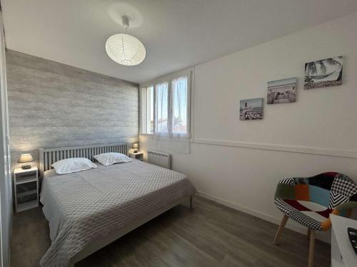 une chambre avec un lit, une fenêtre et une chaise dans l'établissement Appartement moderne 2 pièces avec parking à Saint-Hilaire-de-Riez - FR-1-224C-331, à Saint-Hilaire-de-Riez