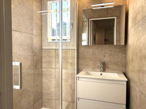 une salle de bain avec un lavabo et un miroir dans l'établissement Confort au Lavandou : 2 pièces, clim, parking - FR-1-251-856, au Lavandou