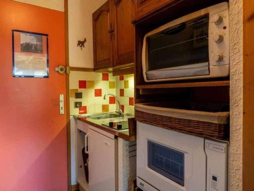 une cuisine avec un micro-ondes et un évier dans l'établissement Studio alpin mezzanine, 4 pers, animaux acceptés, parking en option - FR-1-291-1022, à Valmorel