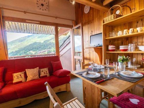 ein Wohnzimmer mit einem roten Sofa und einem Tisch in der Unterkunft Studio alpin mezzanine, 4 pers, animaux acceptés, parking en option - FR-1-291-1022 in Valmorel