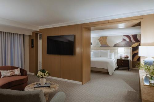 a hotel room with a bed and a tv at Regent Santa Monica Beach in Los Angeles