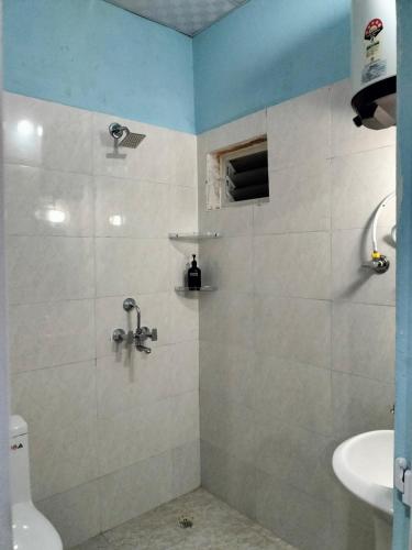 a bathroom with a shower with a toilet and a sink at Into the mountain in Pokhara