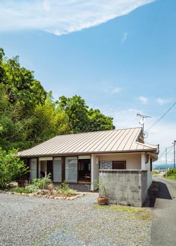 a house with a metal roof on a street at 網ノ屋 - Aminoya Beach House Ezura in Shirahama