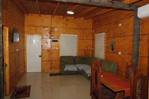 a living room with a couch and a table at Cabañas El Pescador Dalcahue in Dalcahue