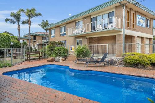 a swimming pool in front of a house at Seaspray in Merimbula