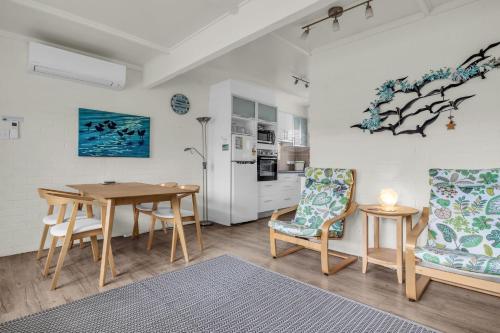 a kitchen and dining room with a table and chairs at Seaspray in Merimbula