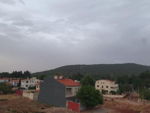 eine Stadt mit Häusern und einem Berg im Hintergrund in der Unterkunft Dar diafa in Imouzzer du Kandar