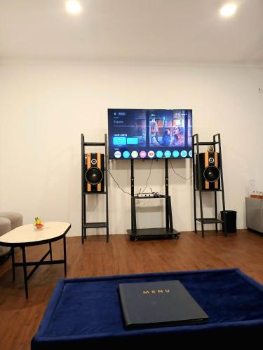 a room with a flat screen tv and speakers at Nunia Tamansari Hotel in Kumprung