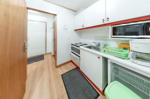une petite cuisine avec un évier et un micro-ondes dans l'établissement Studio accueillant à Gérardmer, 31 m² avec vue sur montagne, à Gérardmer
