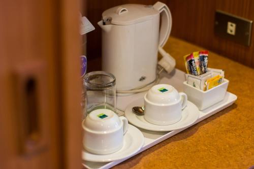 a tray with cups and saucers on a counter at Bangkok Palace Hotel in Bangkok