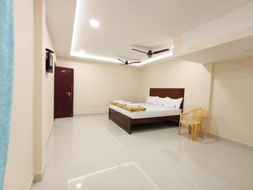 a bedroom with a bed and a chair in it at Selvi Residency in Rāmeswaram