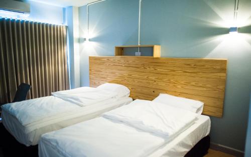 two beds in a hotel room with white sheets at KENCOZY accommodation in Bangkok