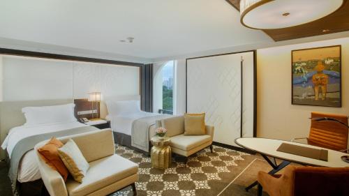a hotel room with a bed and a desk and chair at InterContinental Dhaka by IHG in Dhaka