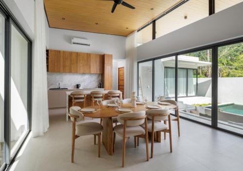 an open kitchen and dining room with a wooden table and chairs at Villa Amour 3 Bedroom Spa Pool Retreat near Beach - Lamai in Lamai