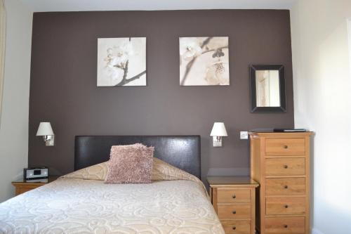um quarto com uma cama e três fotografias na parede em Geminian em Harrogate