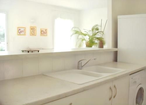 Una cocina blanca con fregadero y ventana. en Villa reposante à Solaro avec piscine privée et jardin, en Solaro