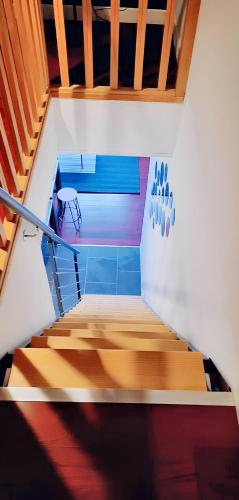 un escalier avec du parquet et une balustrade bleue dans l'établissement Appartement cocooning à Raismes - 48 m² - Idéal pour 4 personnes, à Raismes