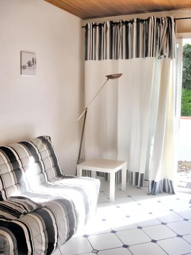 une chambre avec un lit, une table et une fenêtre dans l'établissement Maison accueillante à Noirmoutier-en-l'Île 45 m² avec jardin privé, à Noirmoutier-en-l'lle